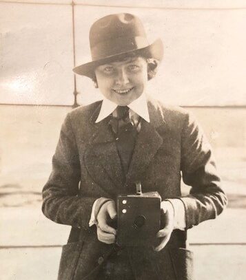 Historical image of a St. Louis holding a photographic camera